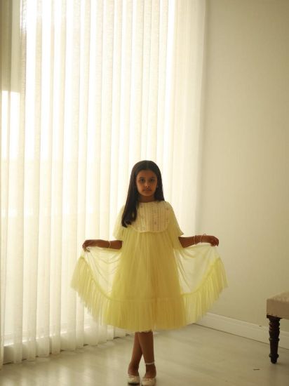 صورة فستان سهرة أصفر أنيق مزين بالؤلؤ على الصدر